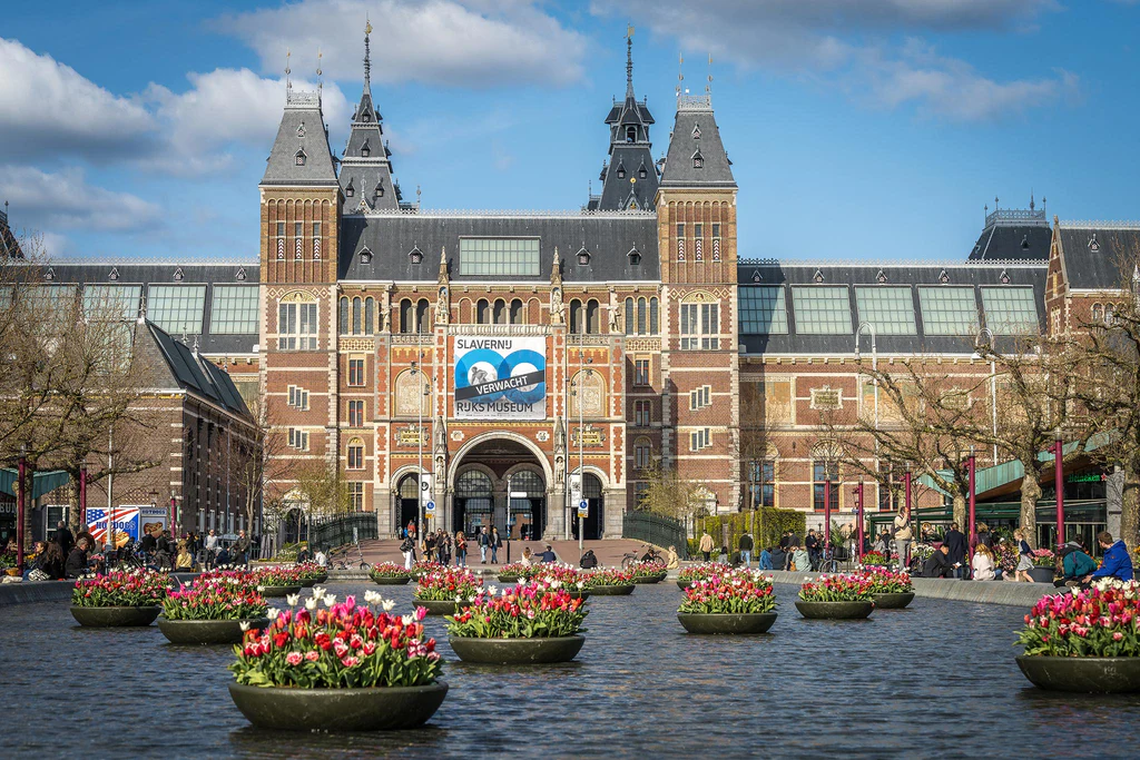 Het rijksmuseum in Amsterdam met tulpen en wolken Architectuurfotografie